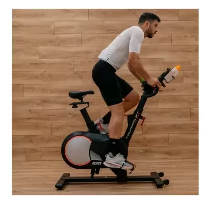 Bicicleta estática preta e cinzenta com detalhes laranja e suporte para garrafa