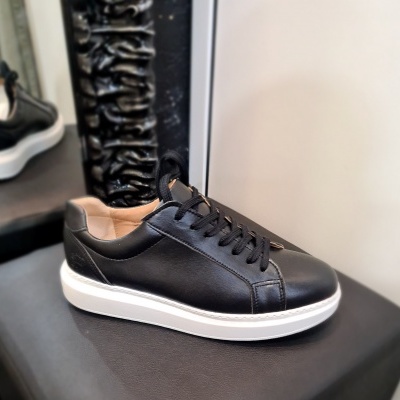 Tênis preto com sola branca sobre superfície preta em loja