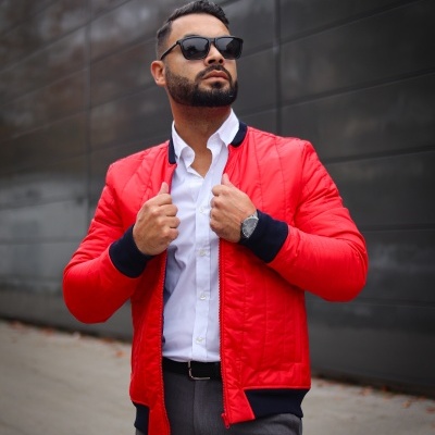 Homem com casaco bomber vermelho e camisa branca em ambiente urbano