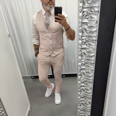 Homem com fato bege e camisa branca em espelho com moldura prateada