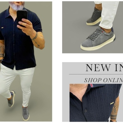 Homem de camisa preta e calças brancas com sapatilhas cinzentas em fundo cinzento.