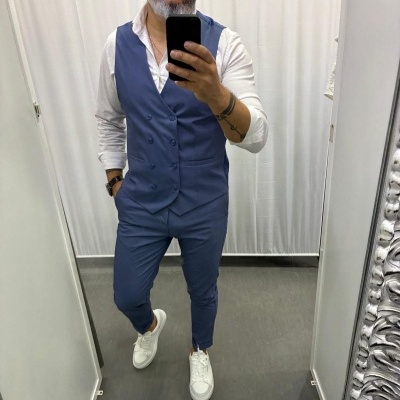 Homem com fato azul e camisa branca a tirar selfie num espelho