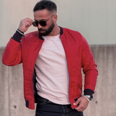 Homem com casaco vermelho e óculos de sol num ambiente exterior