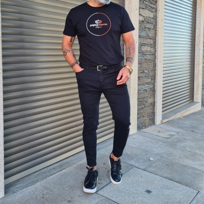 Homem com roupa preta e sapatos pretos em exterior urbano