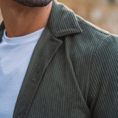 Casaco verde escuro de veludo com riscas verticais e t-shirt branca