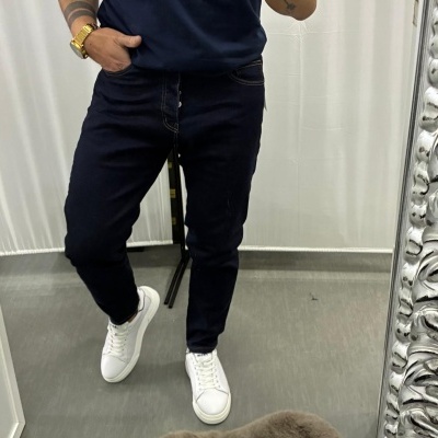 Calças de ganga azuis escuras com sapatilhas brancas à frente de espelho prateado