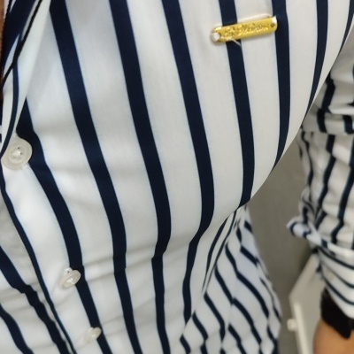 Camisa branca com riscas azuis e distintivo dourado
