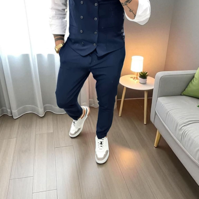 Homem com colete azul e sapatilhas brancas em ambiente interior