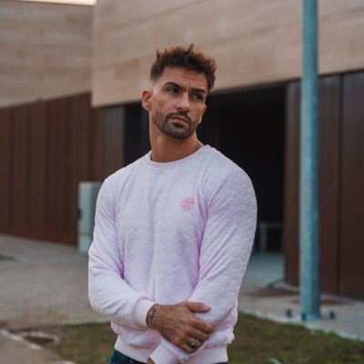 Homem com sweat shirt rosa clara e calças azuis em rua moderna