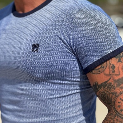 T-shirt azul com padrão branco e gola azul escura com logo bordada no peito