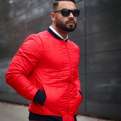 Casaco vermelho acolchoado com detalhes pretos usado por homem