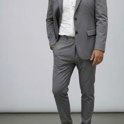 Homem vestido com fato cinza, camisa branca e ténis brancos