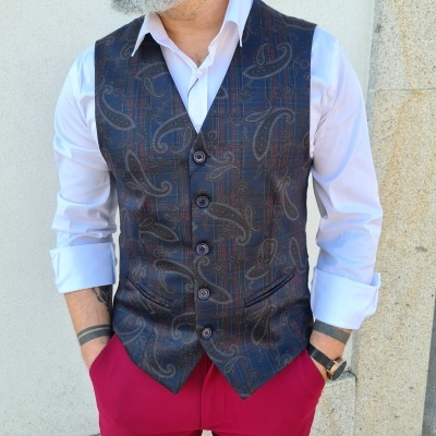 Colete masculino padrão paisley em tons escuros com camisa branca e calças rosa choque