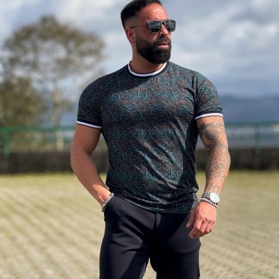 Homem com t-shirt estampada e calças pretas ao ar livre