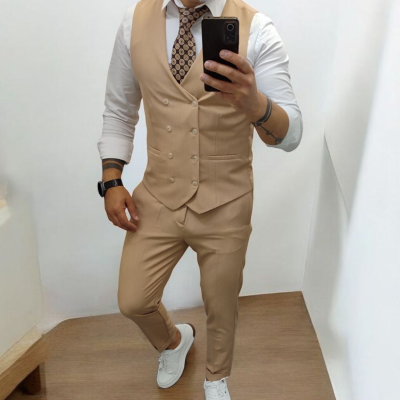 Homem com colete e calças castanhas claras, camisa branca, gravata padrão geométrico, sapatilhas brancas, selfie frente a um espelho.