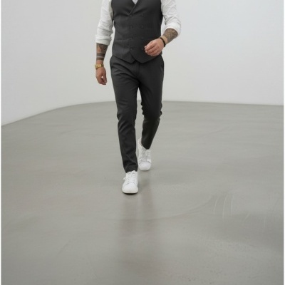 Homem com roupa formal cinzenta e sapatilhas brancas