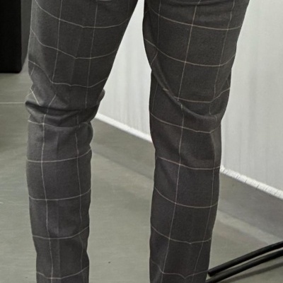 Calças cinzentas de padrão xadrez com ténis brancos