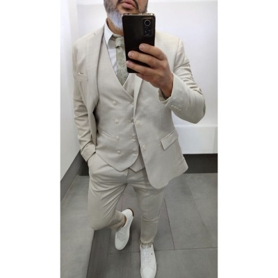 Homem com fato bege claro e sapatos brancos em fundo branco