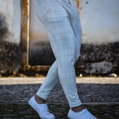 Calças brancas com padrão de quadrícula azul usadas com sapatilhas brancas e t-shirt vermelha