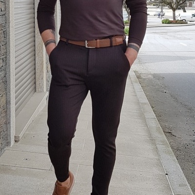 Homem com camisa preta de manga comprida, calças e cinto castanho, e sapatos castanhos