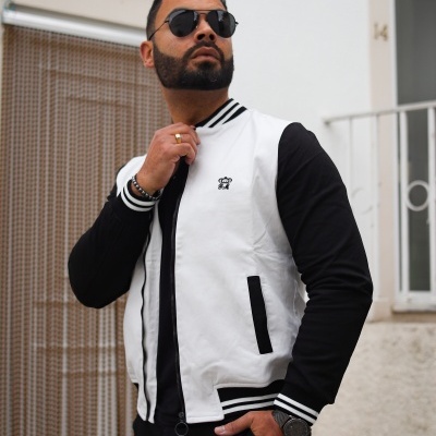 Homem com casaco bomber preto e branco com logótipo no peito