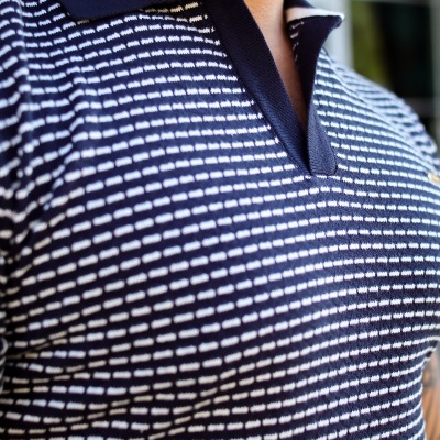 Polo masculino preto com linhas brancas e gola preta.