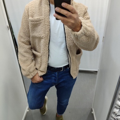 Casaco bege tipo sherpa com fecho preto em prova em cabine