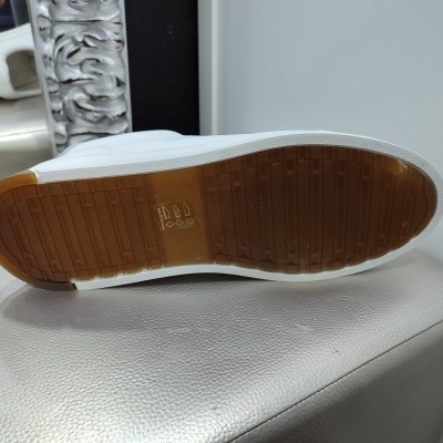 Sola de sapato branco com sola de borracha castanha e texto BOA MOC