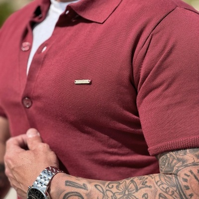 Camisa polo vermelha com manga curta e detalhe metálico no peito