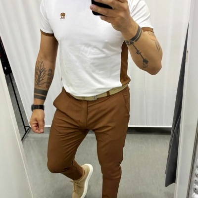 Homem com roupa casual branca e castanha em selfie num espelho