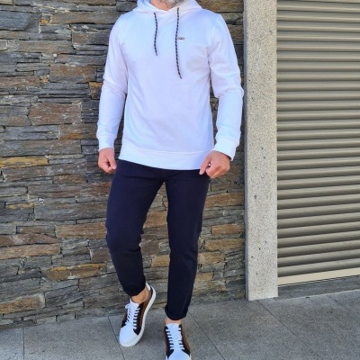 Homem com hoodie branco, calças pretas e ténis brancos
