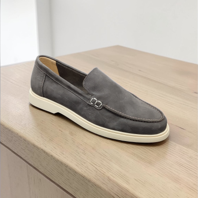 Sapato mocassim cinzento em pele sobre madeira clara