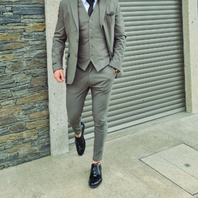 Homem com fato cinza e sapatos pretos em ambiente urbano