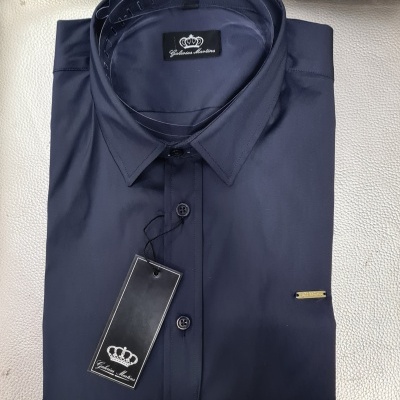 Camisa azul escuro dobrada com etiqueta preta pendurada