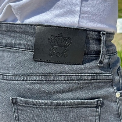 Calças de ganga cinza com etiqueta preta na cintura e t-shirt branca