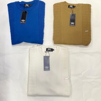 Três camisolas de malha azul, camel e branco com etiquetas negras e padrão trançado nas mangas