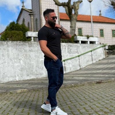 Homem com roupa casual na rua junto a edifício antigo