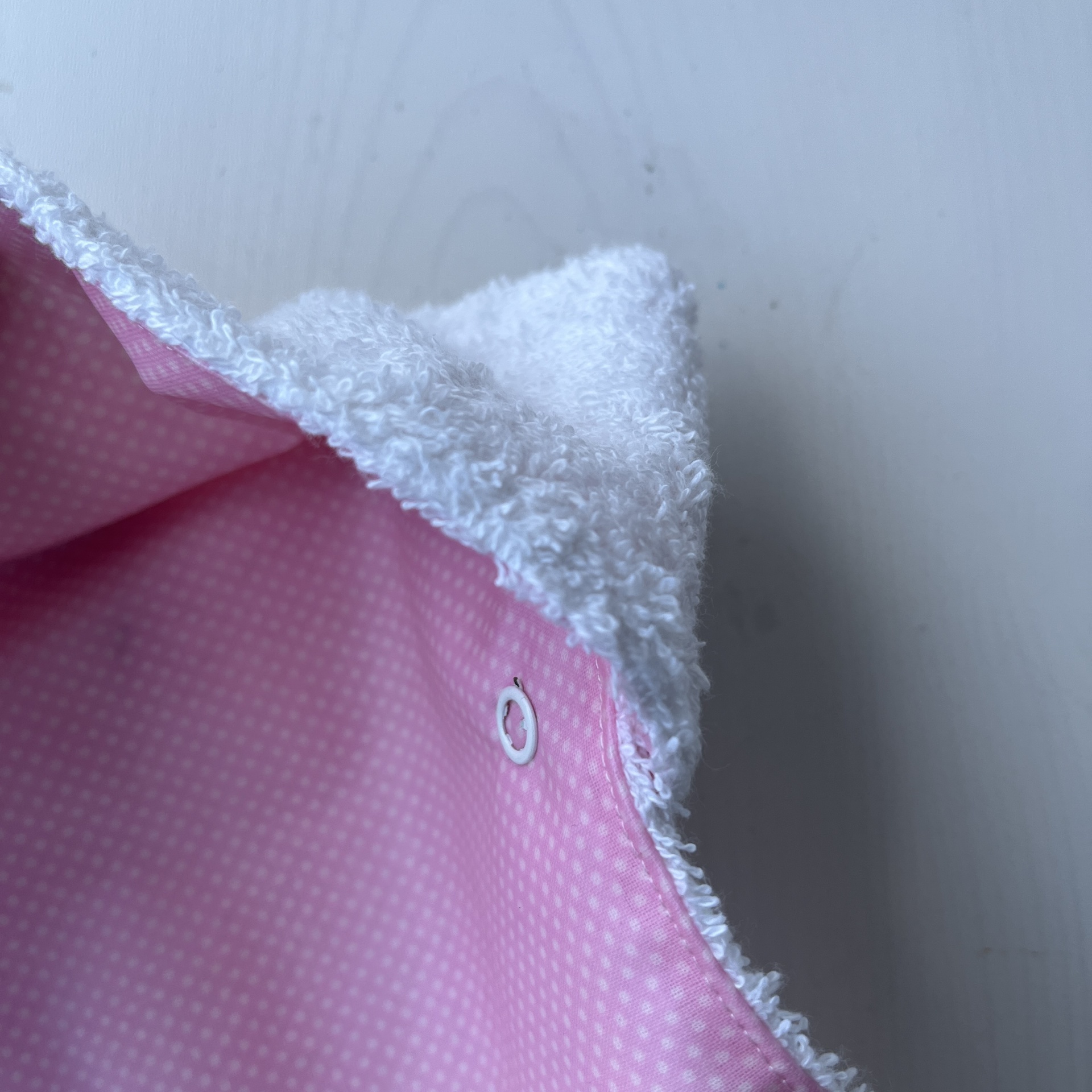 Fralda rosa com padrão de pontos brancos e interior felpudo branco