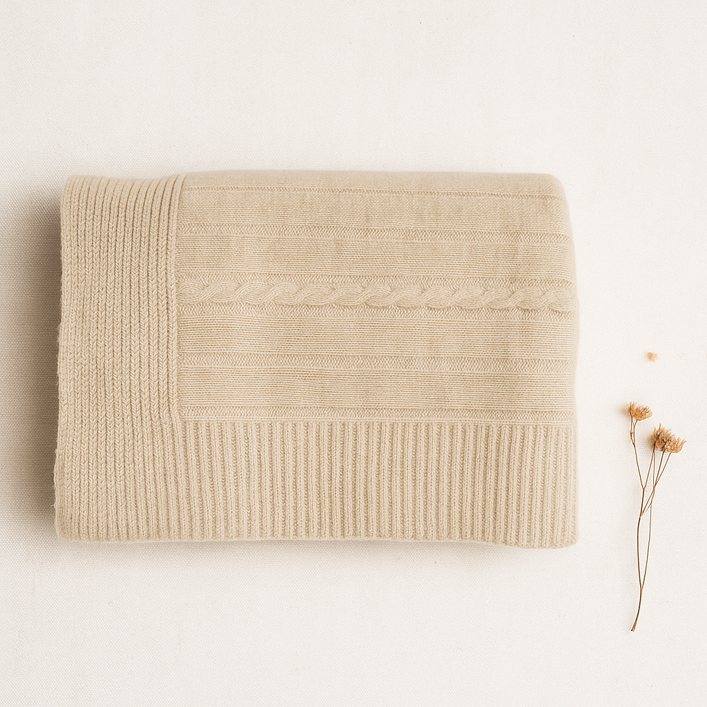 Manta bege claro com padrões de pontos, flores secas ao lado