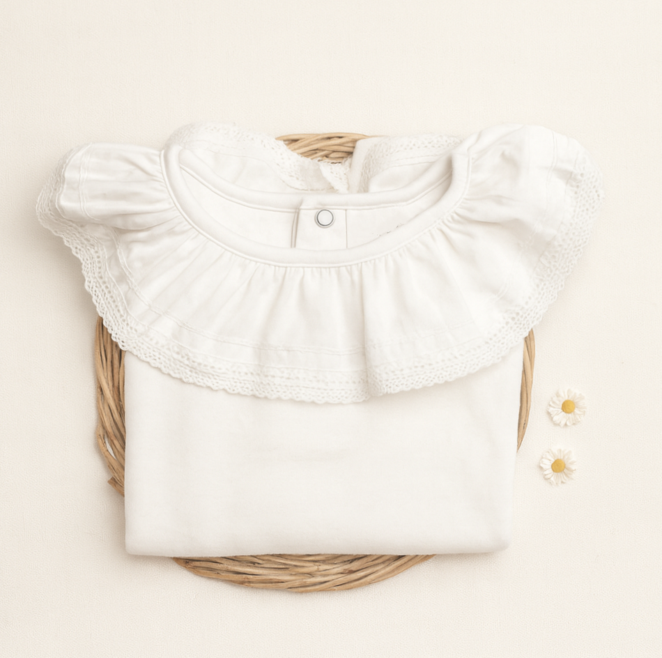 Blusa branca de algodão com gola redonda e renda sobre base de verga com flores brancas.