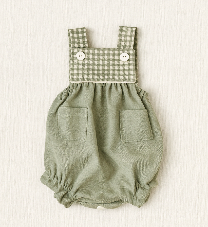 Macacão de bebé verde claro com padrão xadrez nas alças e botões brancos