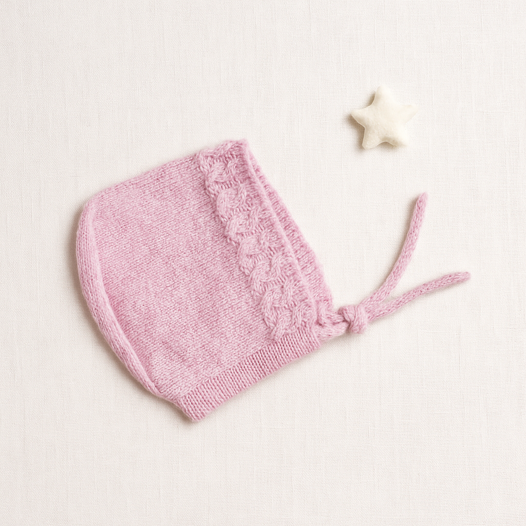 Gorro cor-de-rosa de malha com cordão e estrela branca ao lado