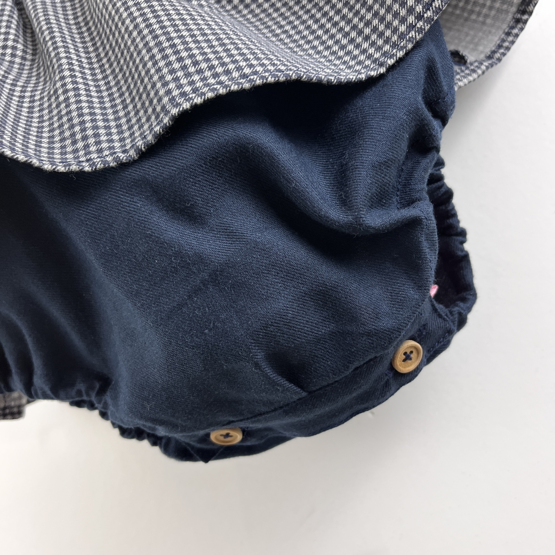 Detalhe de vestido de bebé com saia pied de poule e bombazine azul