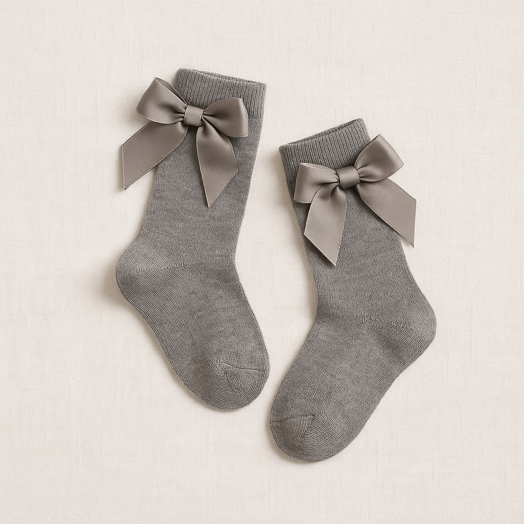 Meias cinzentas com laços de fita cinza escuro sobre fundo branco.