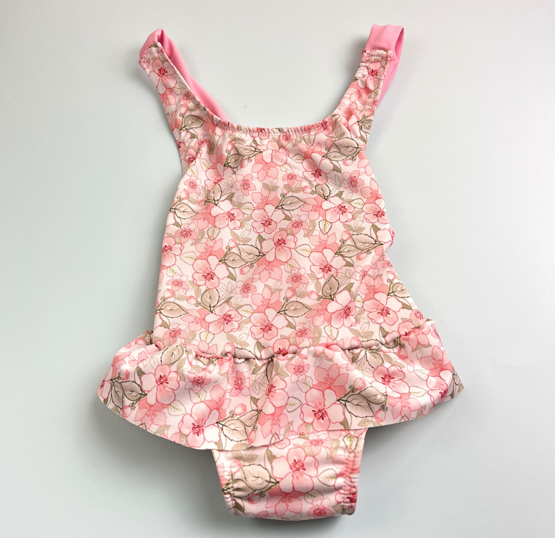 Fato de banho rosa com padrão floral e saia para criança
