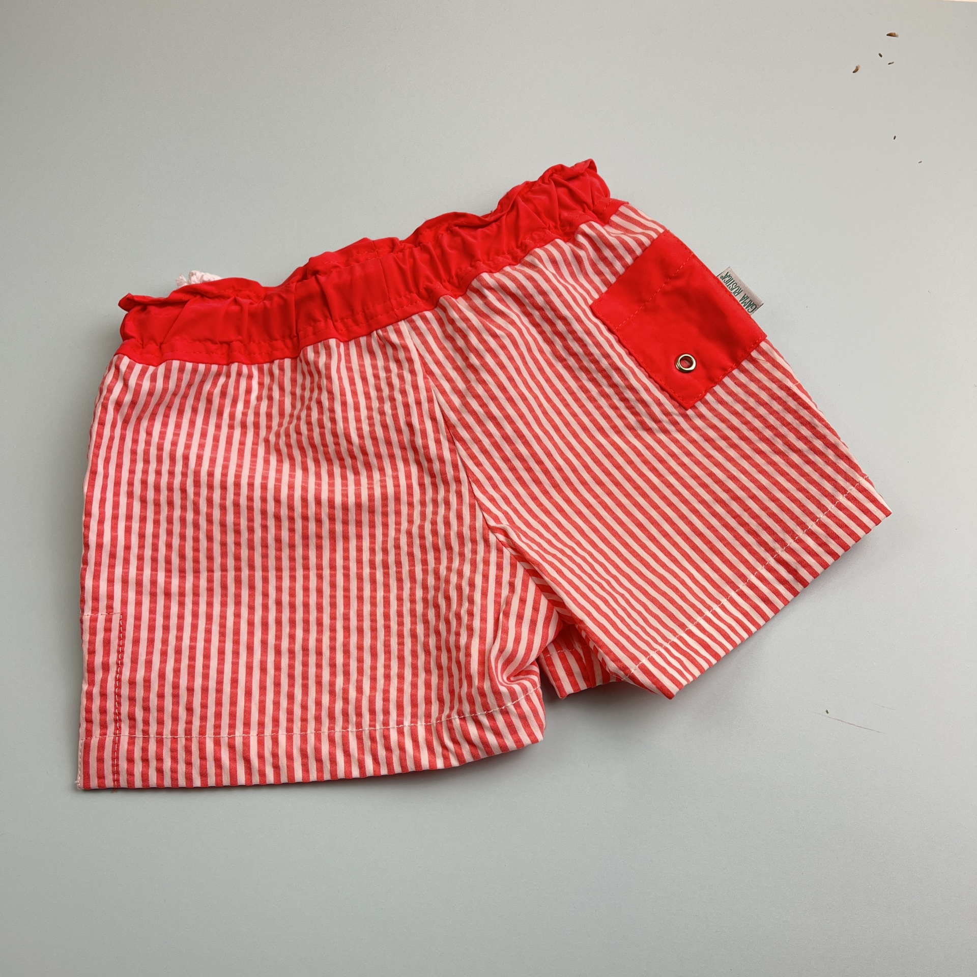 Calções de criança listrados vermelhos e brancos com bolso vermelho