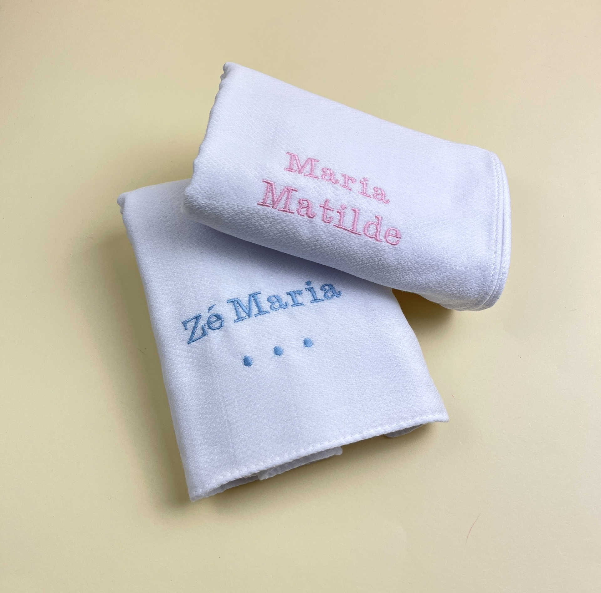 Dois panos de mão brancos com bordados coloridos