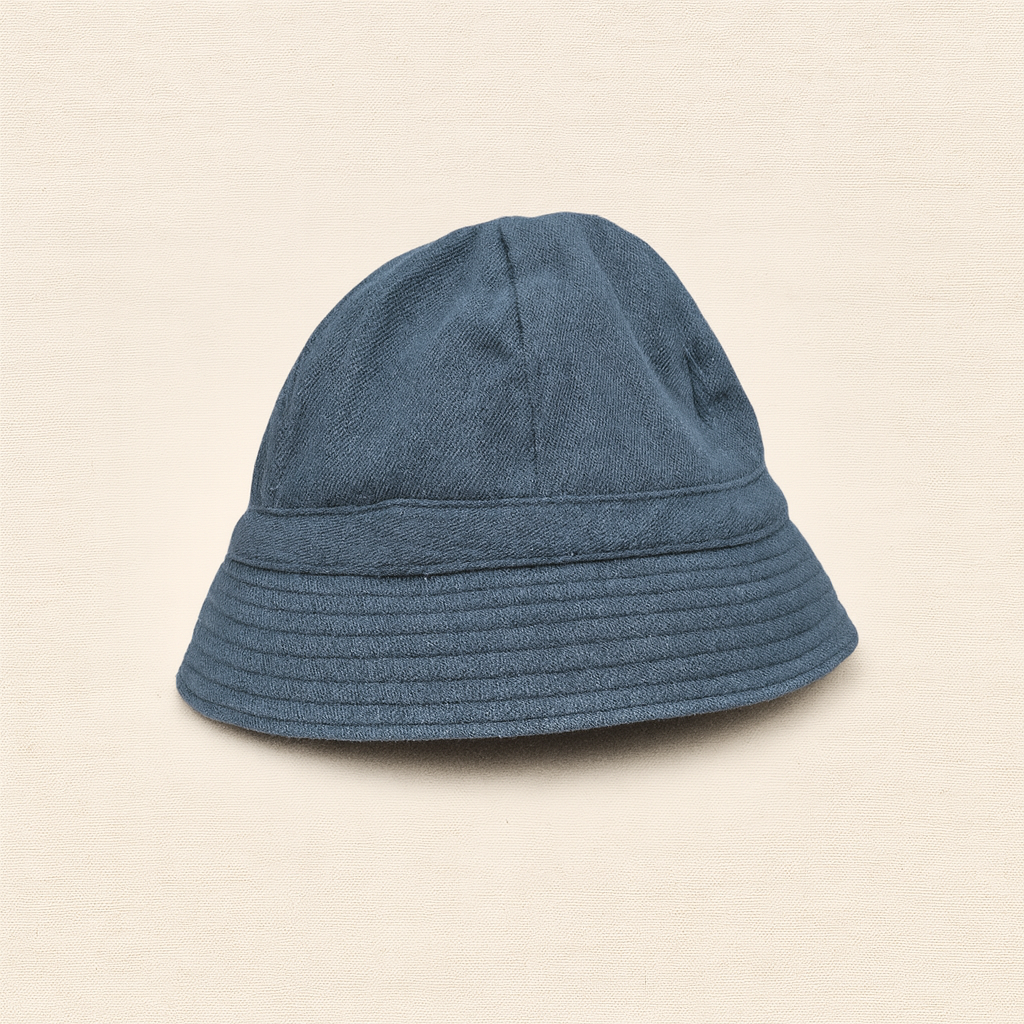 Chapéu tipo balde em tecido azul escuro sobre fundo bege