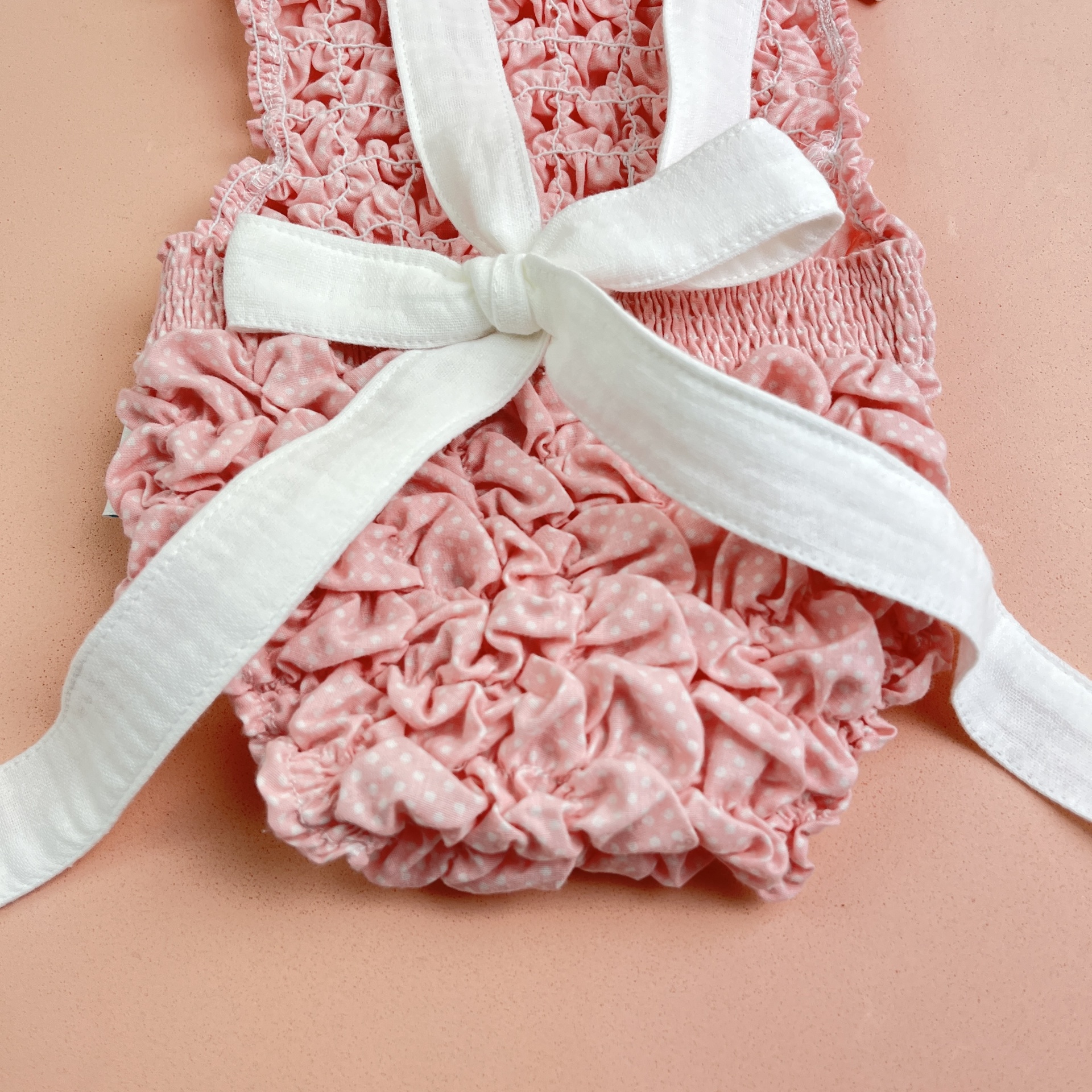 Pano rosa com textura franzida e laço branco