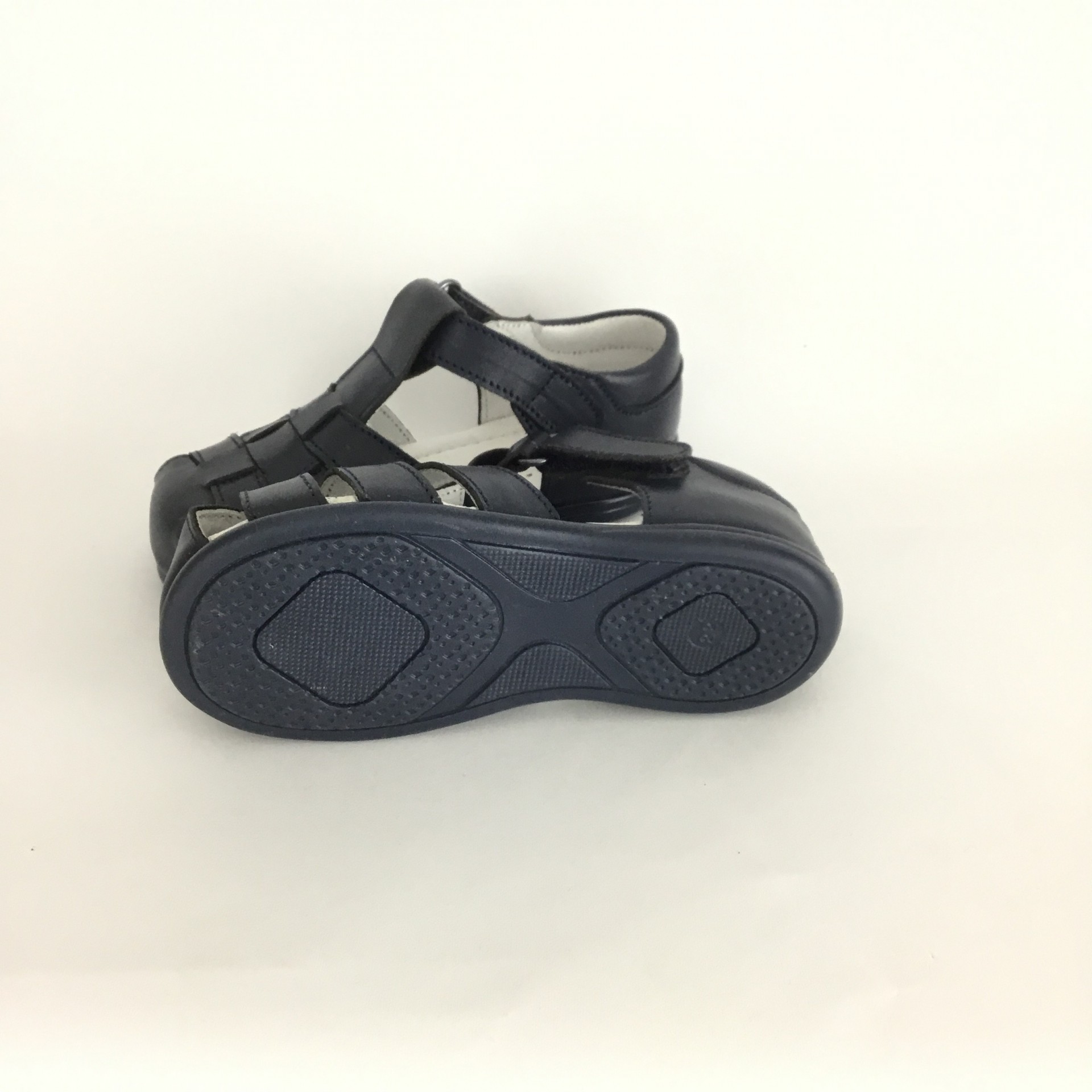 Sandálias pretas para criança com sola antiderrapante sobre fundo branco